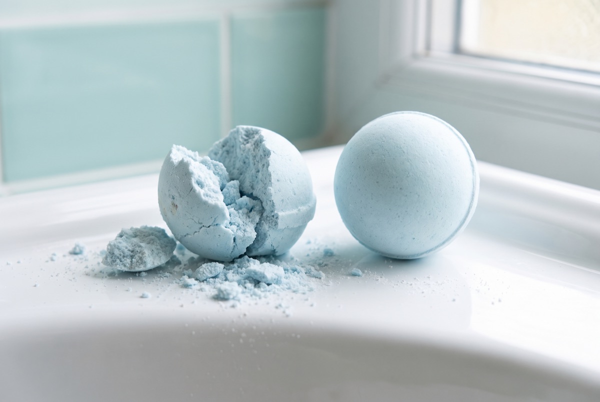 A cracked crumbling bath bomb next to a smooth perfectly formed one